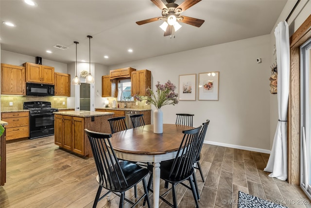 dining area with ceiling fan, sink, and light hardwood / wood-style floors