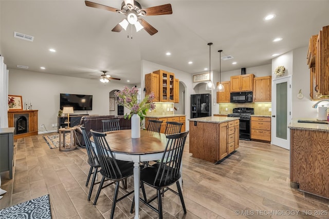 dining space with ceiling fan, sink, and light hardwood / wood-style floors