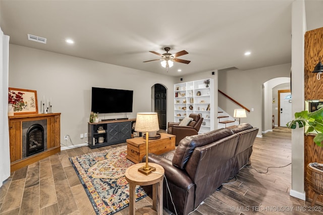 living room with wood-type flooring and ceiling fan