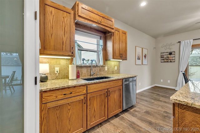 kitchen featuring sink, tasteful backsplash, dark hardwood / wood-style floors, dishwasher, and light stone countertops