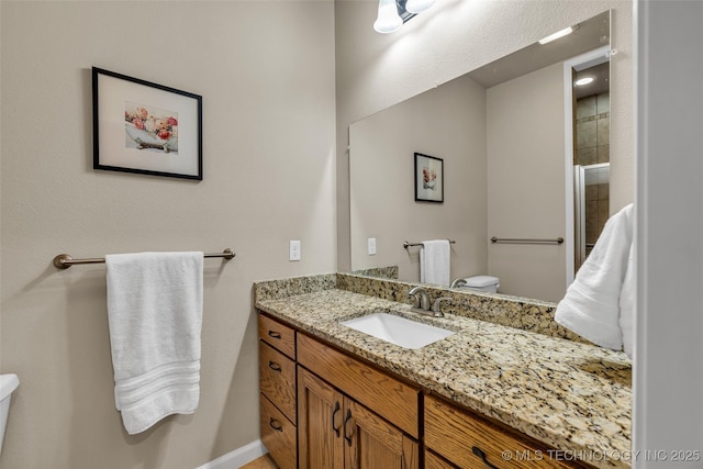 bathroom featuring vanity, a shower with shower door, and toilet