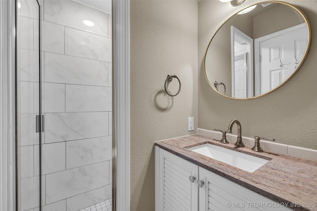 bathroom with vanity and a shower with shower door