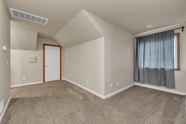 additional living space featuring lofted ceiling and carpet