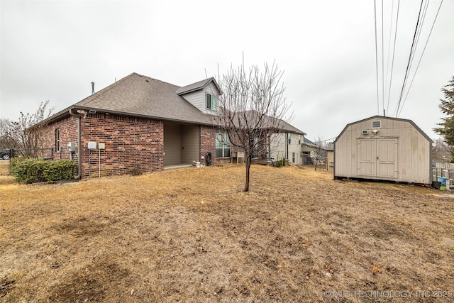 back of property featuring a storage unit and a lawn