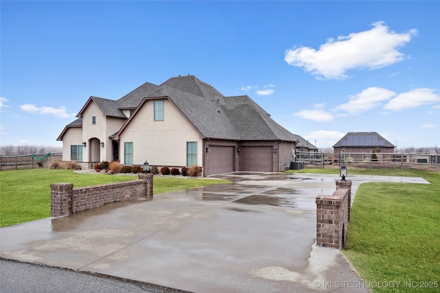 french country home featuring central AC unit, a garage, and a front yard