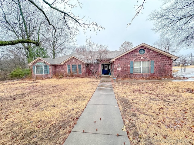 ranch-style house featuring brick siding and a front lawn