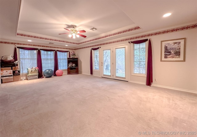 interior space with light carpet, baseboards, a tray ceiling, and crown molding