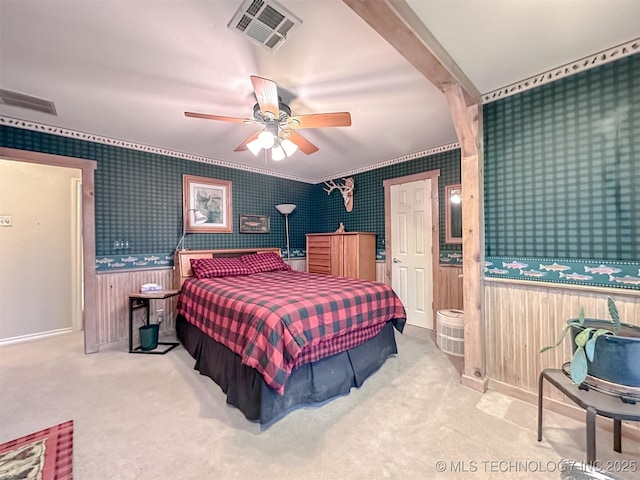 bedroom with a ceiling fan, light colored carpet, visible vents, and wallpapered walls