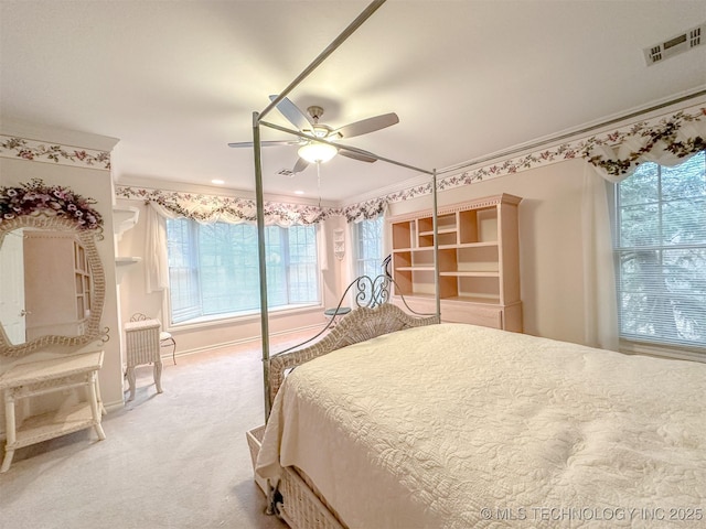 bedroom featuring ceiling fan, visible vents, baseboards, carpet, and crown molding