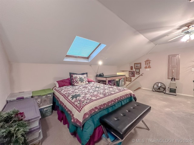 bedroom with vaulted ceiling with skylight, carpet flooring, a ceiling fan, and baseboards