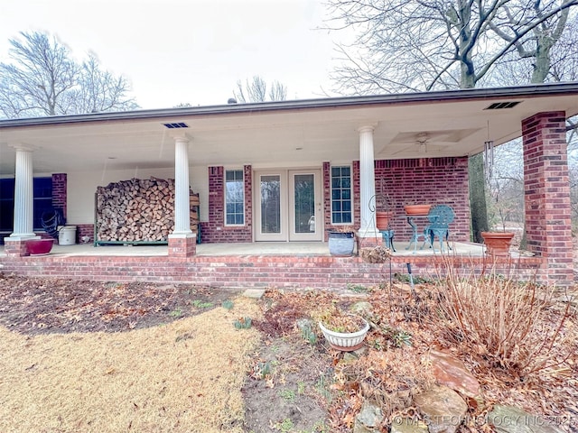 rear view of house featuring covered porch and brick siding