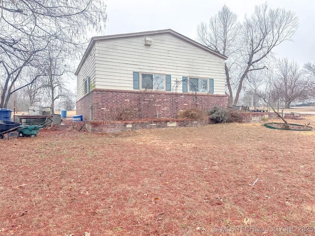 view of side of home with brick siding and crawl space