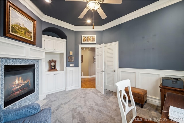 home office with ornamental molding, a fireplace, light colored carpet, and ceiling fan