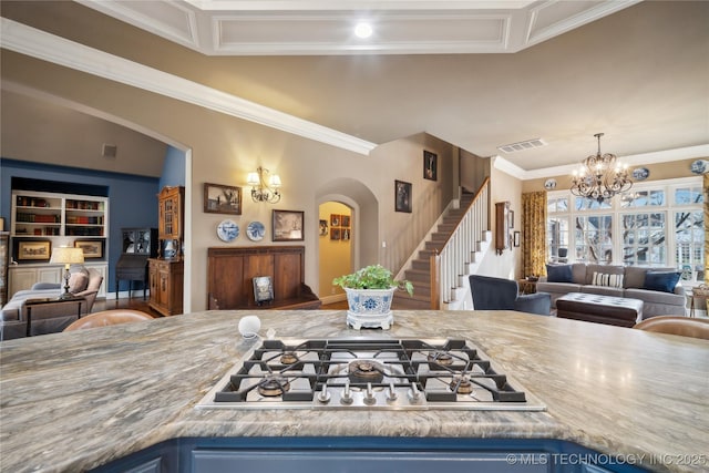 kitchen with built in features, stainless steel gas stovetop, ornamental molding, a notable chandelier, and blue cabinetry