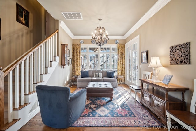 living room with dark wood-type flooring, plenty of natural light, crown molding, and a notable chandelier