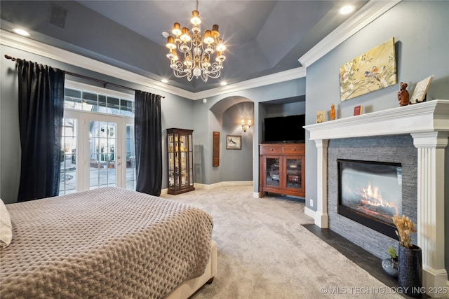 bedroom with an inviting chandelier, a tray ceiling, a fireplace, carpet floors, and ornamental molding