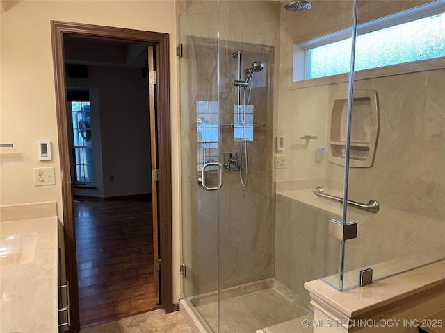 bathroom with a shower with door and hardwood / wood-style flooring