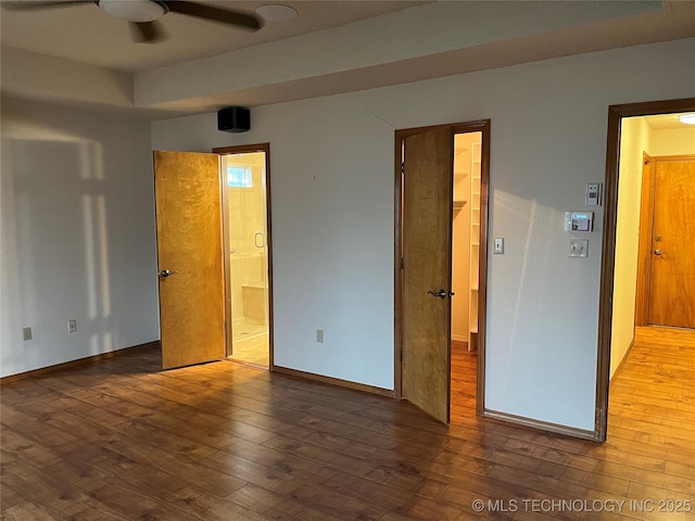 unfurnished bedroom featuring ensuite bath and hardwood / wood-style floors