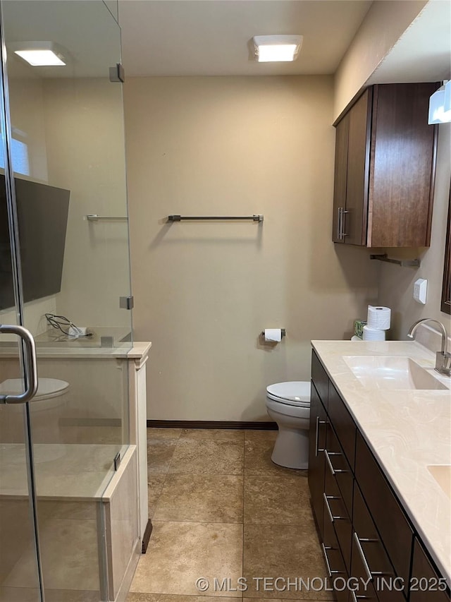 bathroom featuring vanity, toilet, and a shower with shower door