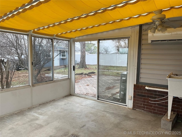 unfurnished sunroom with ceiling fan