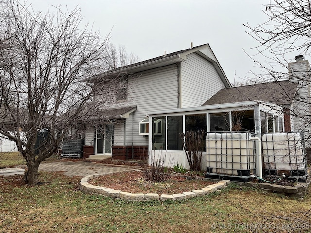 back of property with a sunroom