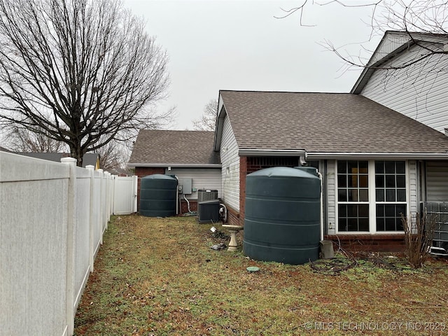 view of side of home featuring a yard and central air condition unit