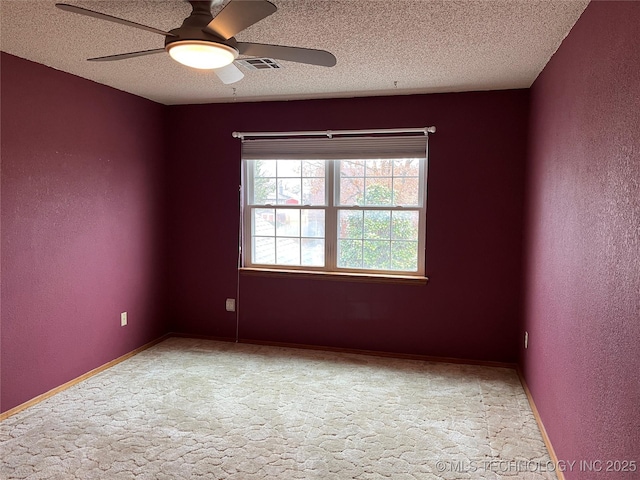 carpeted empty room featuring ceiling fan and a textured ceiling