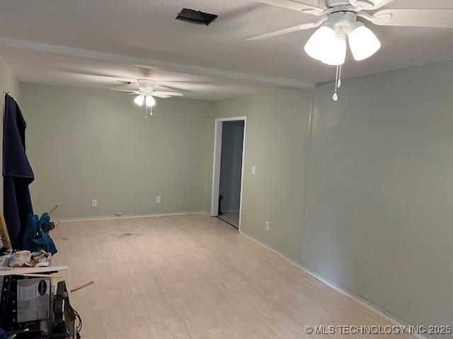 unfurnished living room featuring ceiling fan, baseboards, and light wood-type flooring