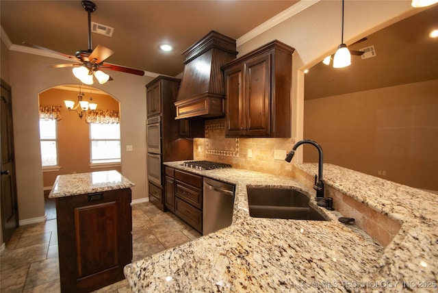 kitchen with sink, stainless steel appliances, light stone counters, decorative backsplash, and custom exhaust hood