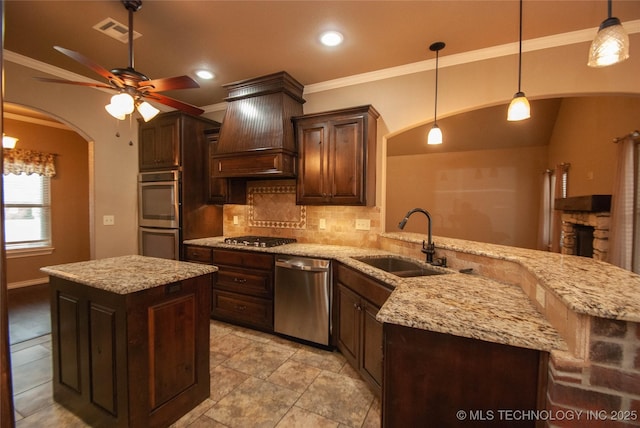 kitchen with pendant lighting, sink, stainless steel appliances, a center island, and custom exhaust hood