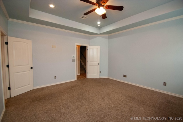 spare room with carpet floors, ornamental molding, a raised ceiling, and ceiling fan