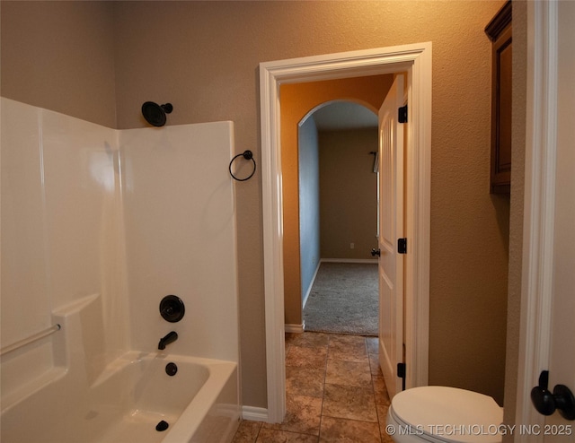 bathroom with shower / bathing tub combination and toilet