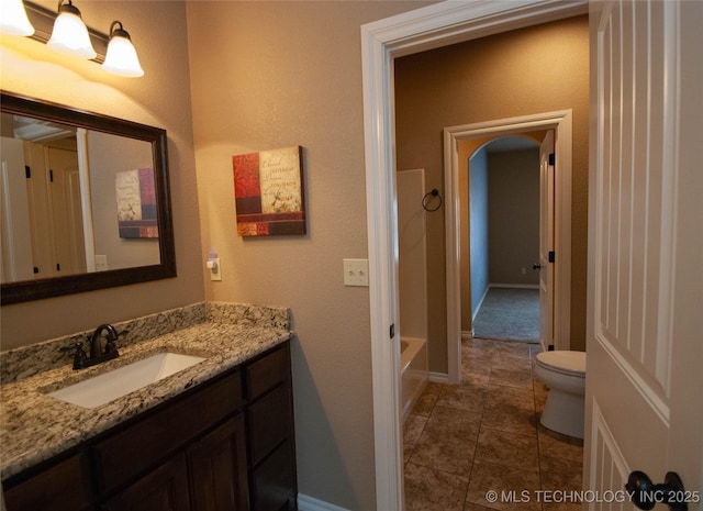 bathroom featuring vanity, tile patterned flooring, a tub, and toilet