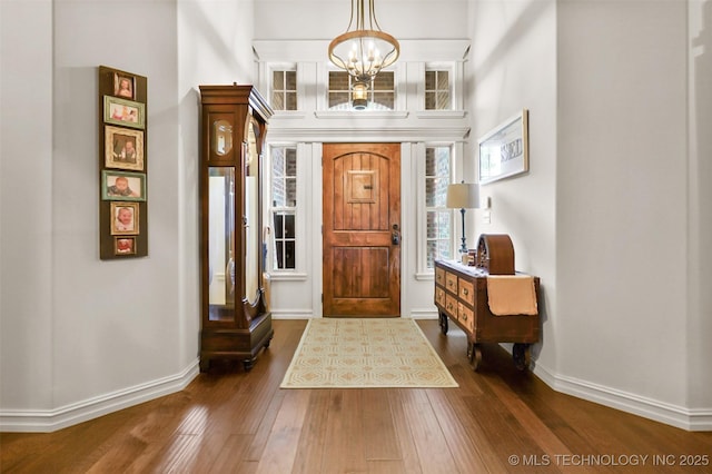 entrance foyer featuring dark hardwood / wood-style flooring and an inviting chandelier