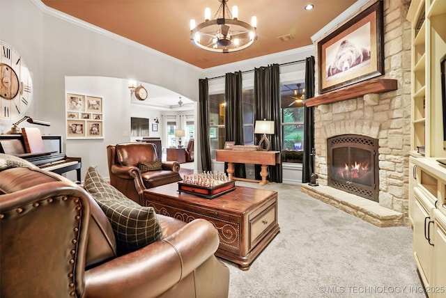 carpeted living room featuring ceiling fan with notable chandelier, a fireplace, and ornamental molding