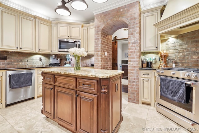 kitchen with custom exhaust hood, tasteful backsplash, a kitchen island, stainless steel appliances, and cream cabinets