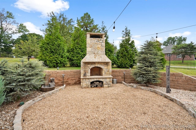 view of yard featuring an outdoor stone fireplace