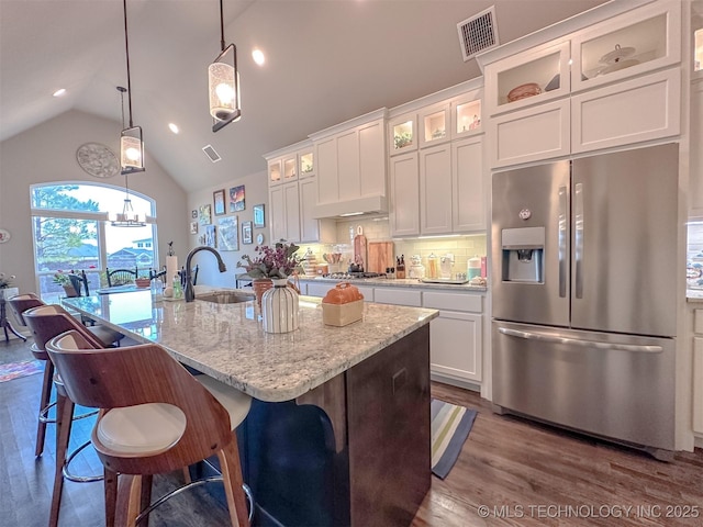 kitchen with sink, hanging light fixtures, appliances with stainless steel finishes, an island with sink, and white cabinets