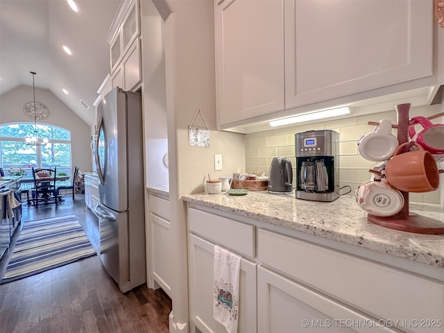 kitchen featuring white cabinetry, stainless steel fridge, and decorative light fixtures