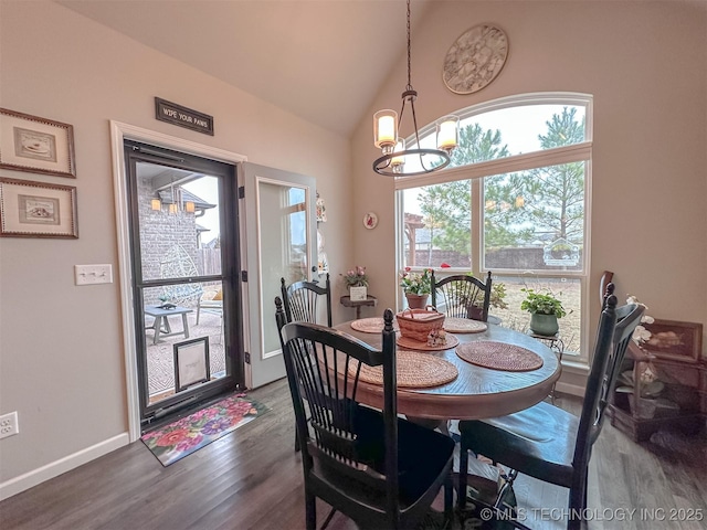 dining space with dark hardwood / wood-style flooring, high vaulted ceiling, and a notable chandelier