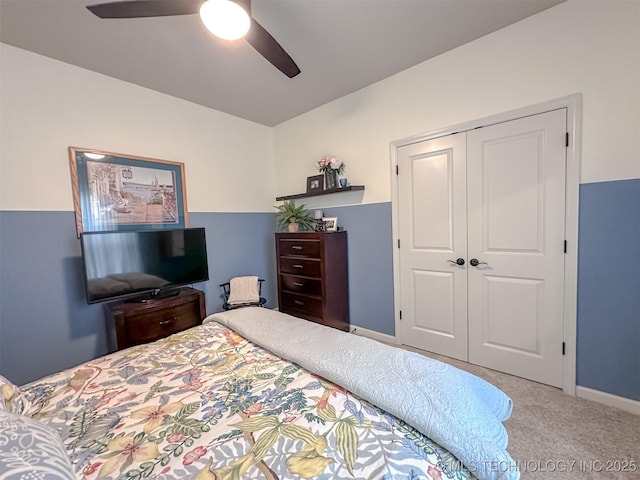 bedroom with light carpet, ceiling fan, and a closet