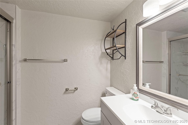 bathroom with vanity, a shower with shower door, a textured ceiling, and toilet