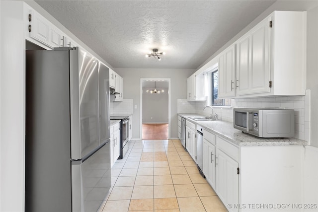 kitchen featuring stainless steel appliances, white cabinetry, sink, and light tile patterned floors