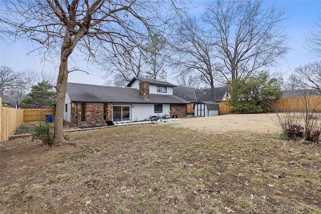 rear view of house with a patio and a shed