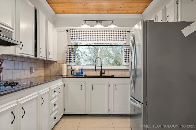 kitchen featuring crown molding, stainless steel fridge, and white cabinets