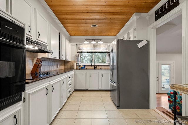 kitchen with stainless steel refrigerator, ornamental molding, oven, black gas stovetop, and white cabinets