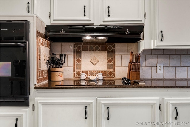 kitchen with dark stone countertops, tasteful backsplash, black appliances, and white cabinets