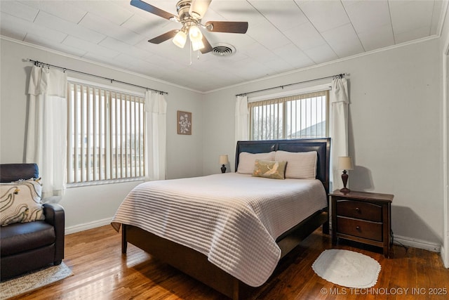 bedroom featuring hardwood / wood-style flooring, ornamental molding, and ceiling fan