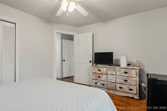 bedroom featuring dark wood-type flooring, ceiling fan, and a closet