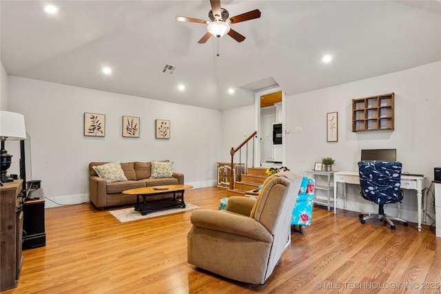 living room with light hardwood / wood-style flooring, ceiling fan, and vaulted ceiling